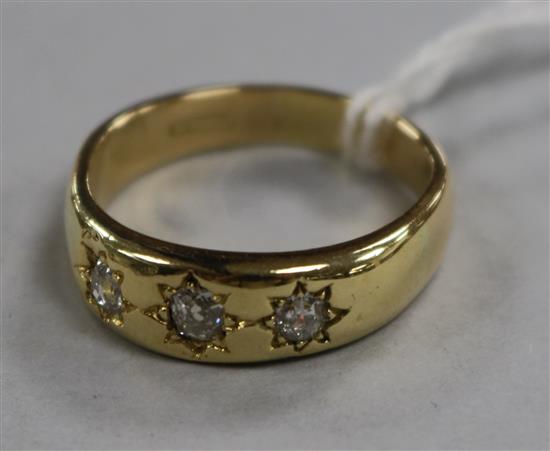 A gentlemans 18ct gold and gypsy set three stone diamond ring, size V.